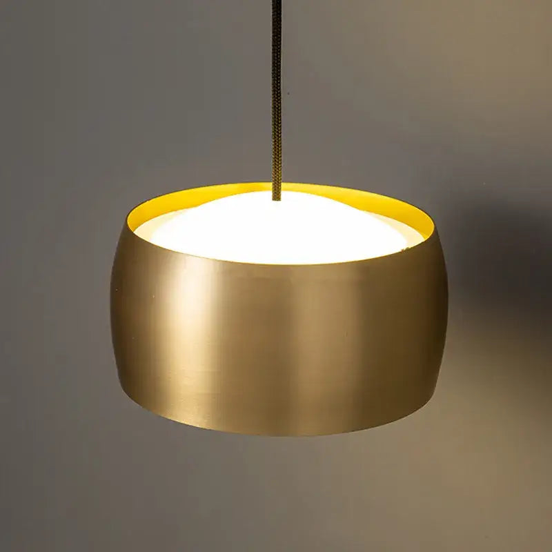 Minimalist brushed brass wall lamp with matte black led featuring a sleek gold pendant light and yellow inner rim