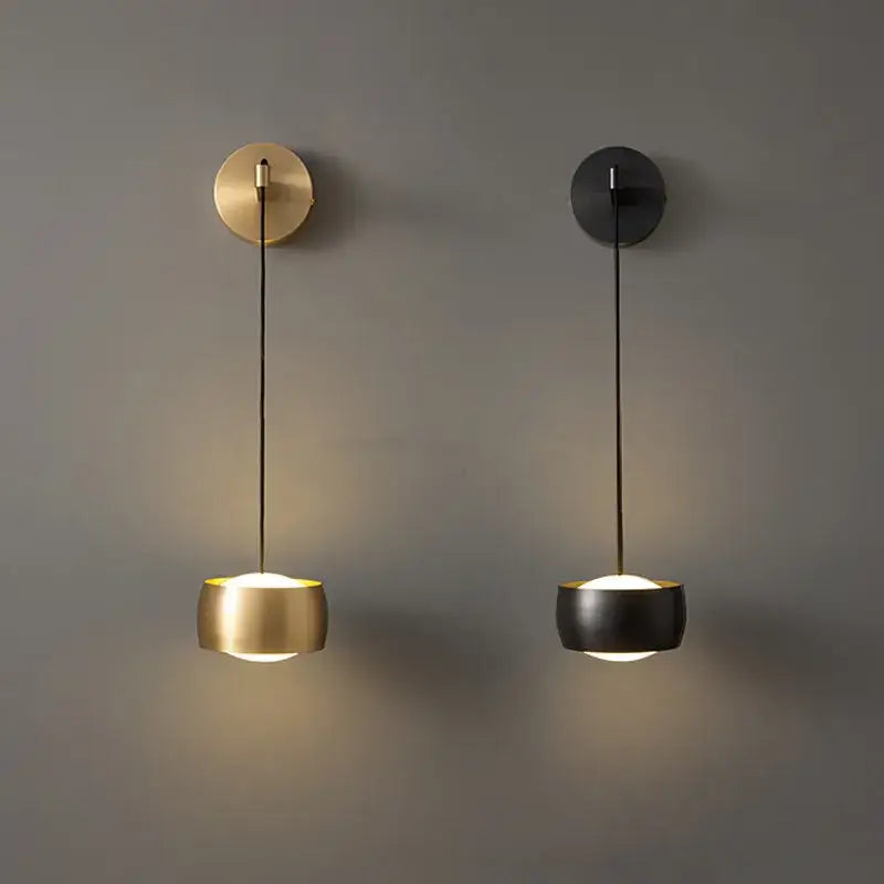 Two minimalist wall lamps with brushed brass and matte black cylindrical shades featuring copper adjustable led cords for bedroom decorbites copper adjustable lighting
