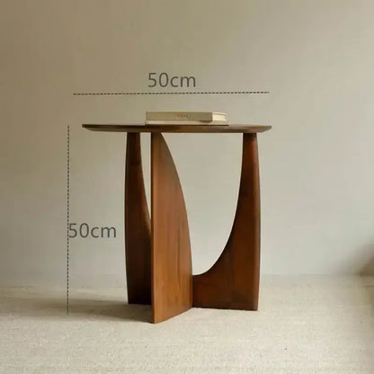 Minimalist circular walnut wood coffee table with warm brown finish and sculpted asymmetrical legs for living room decorbites