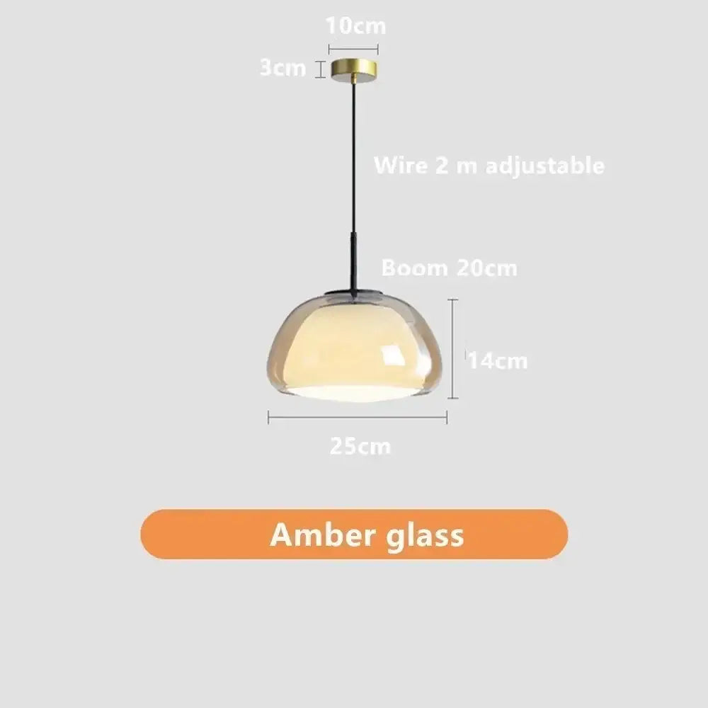 Minimalist jelly pendant lamp with amber glass dome and brass finish suspended by adjustable black wire for living room