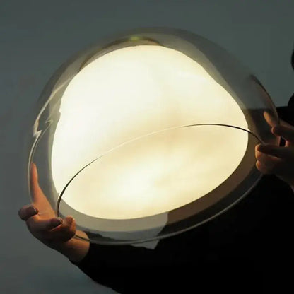 Minimalist clear glass jelly pendant lamp with translucent dome and warm glow for living room lighting