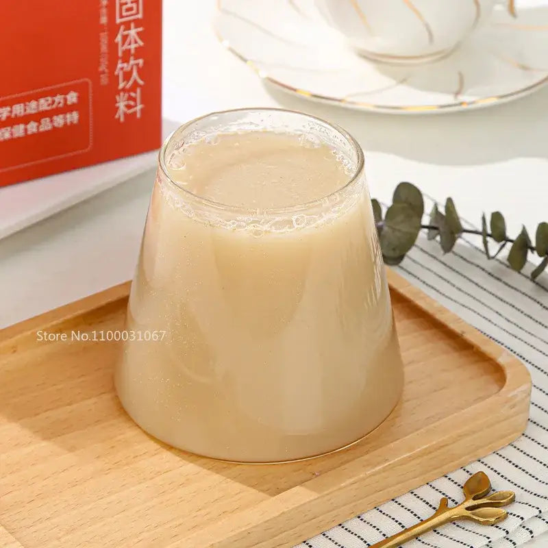 Minimalist clear glass water cup filled with a creamy beverage resting on a light wood tray for kitchen use