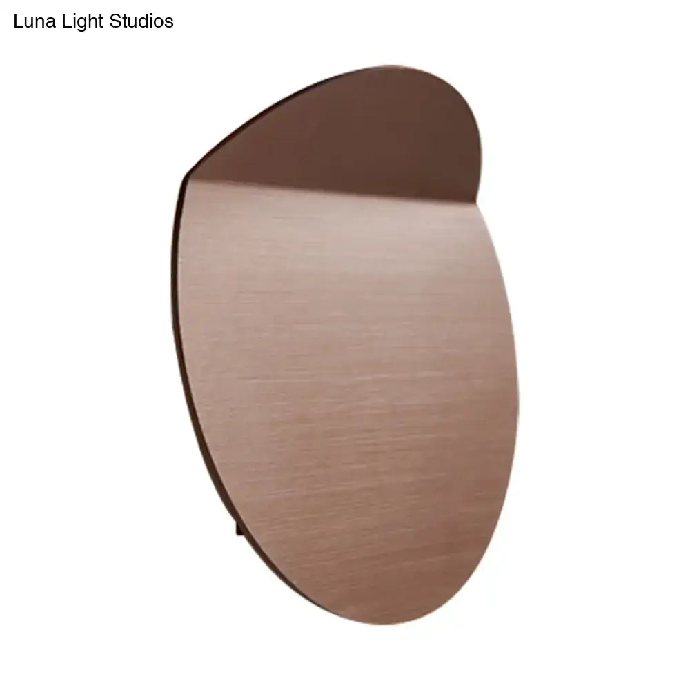 A sleek oval minimalist copper sconce light with brushed finish wall mount and energy-saving led bulb for bedroom use