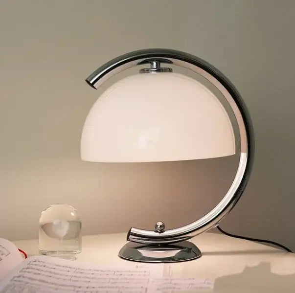 Minimalist cream bauhous mushroom table lamp with chrome-finished curved base and opaque white dome shade for bedroom