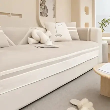 Beige upholstered sofa with matching throw pillows featuring a minimalist cream and beige geometric skirt cover for living room