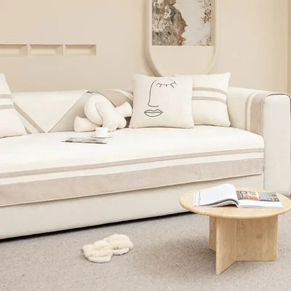 Minimalist cream-colored sofa with beige striped accents and geometric skirt cover for living room seating