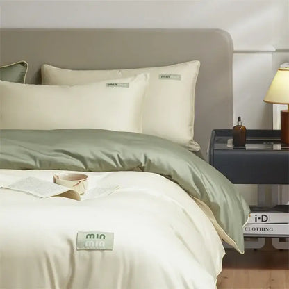 Minimalist cream and green egyptian cotton solid bedding set with cream satin duvet and sage green accents by Mia