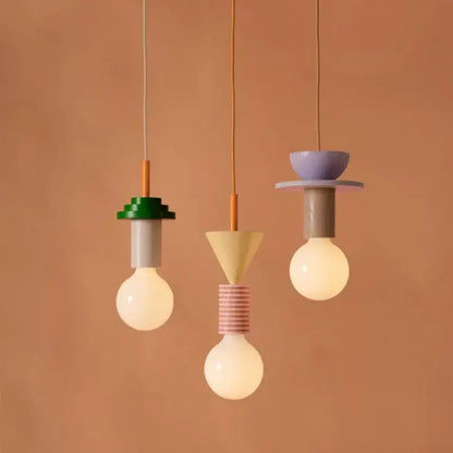 Three colorful nordic wood and ceramic pendant lights with geometric designs hang against a warm wall decorbites colorful nordic pendant light