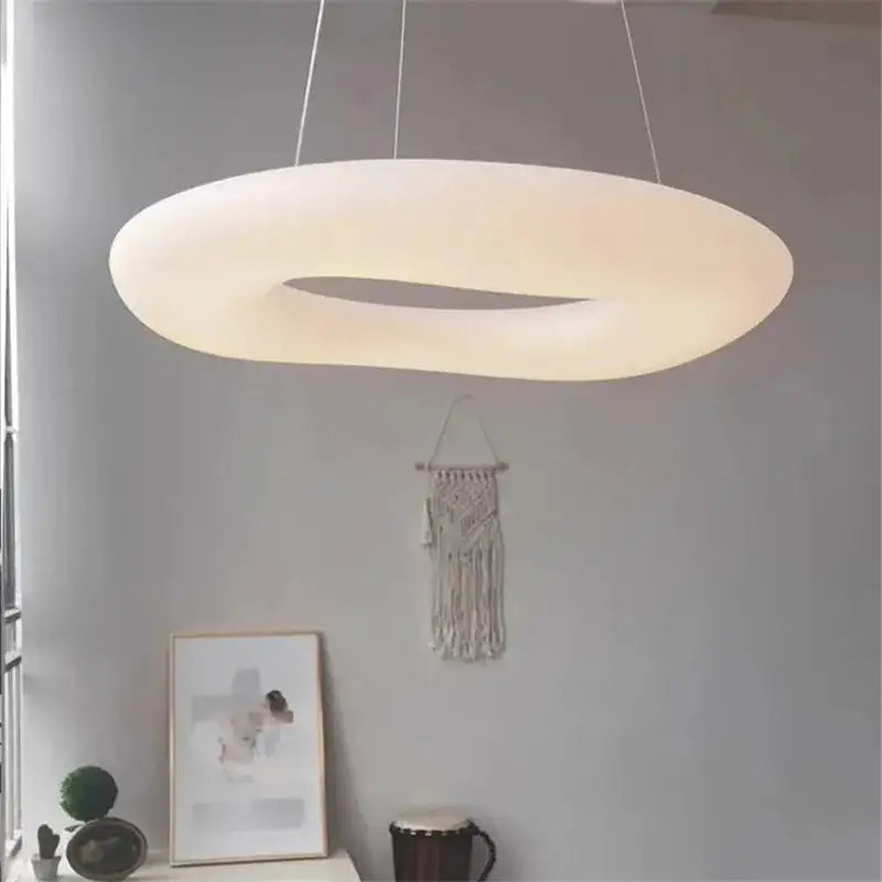 A minimalist frosted white cloud led pendant light with a softly glowing ring design for home office decor