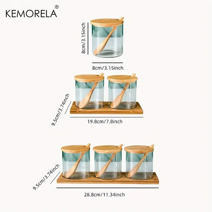 Minimalist glass spice jar set with bamboo lids and wooden spoons on matching bamboo tray for kitchen organization
