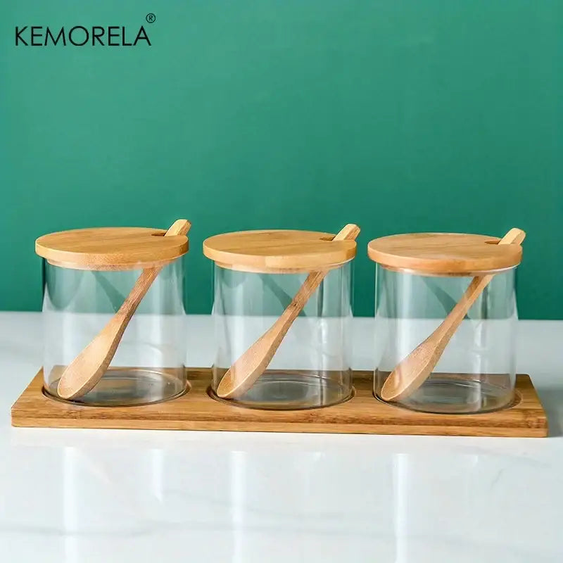 Minimalist glass spice jar set with clear glass jars bamboo lids wooden spoons on bamboo trays for kitchen organization