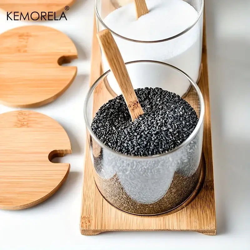 Minimalist glass spice jar filled with black sesame seeds featuring bamboo lid and wooden spoon in spice jar set