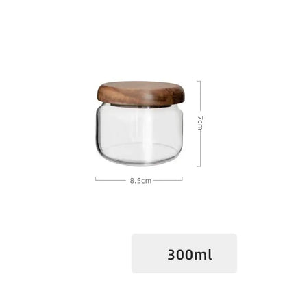 Minimalist glass spice jar with clear glass body and smooth rounded acacia wood lid for kitchen storage