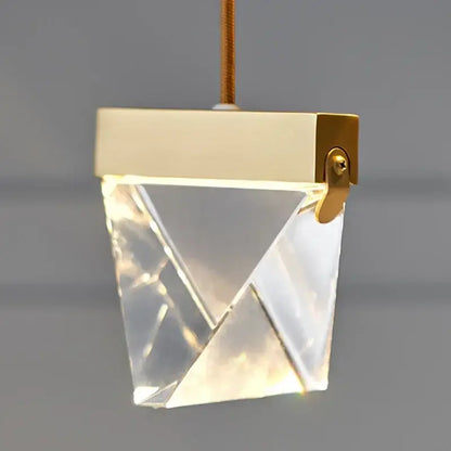 A modern gold-toned decorbites crystal chandelier with faceted crystal body for minimalist dining room lighting