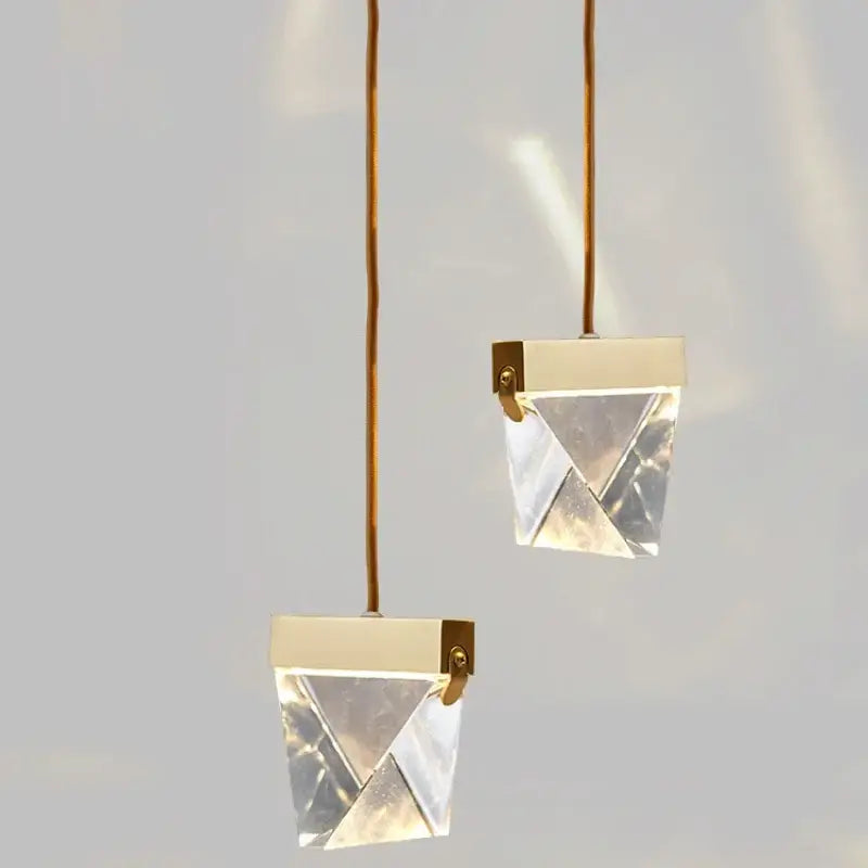 Two minimalist pendant lights with clear faceted crystal prisms and gold cords for decorbites crystal chandelier dining room light