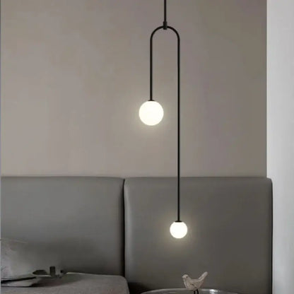 Black minimalist pendant light with double head glass ball frosted bulbs and curved metal arm for bedroom use