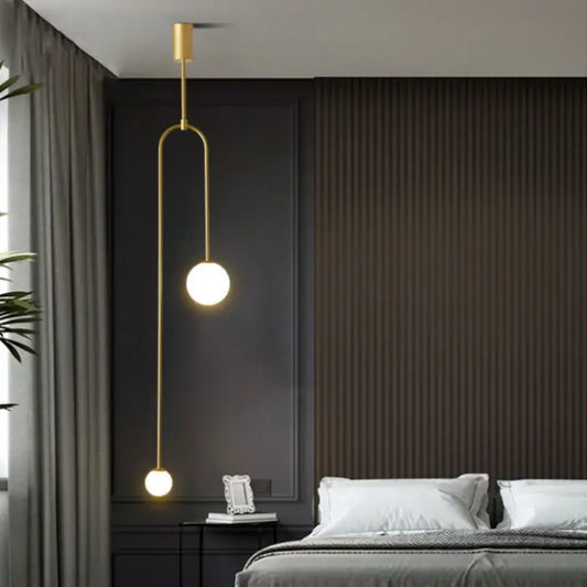 Minimalist gold double head glass ball pendant lights with spherical bulbs and curved metal arm for bedroom lighting