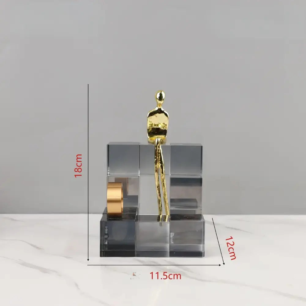 Minimalist gold figurine atop a transparent acrylic geometric cube base as decorbites geometric stair crystal ornament for living room decor