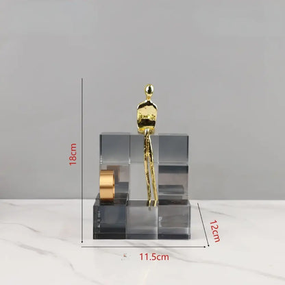 Minimalist gold figurine atop a transparent acrylic geometric cube base as decorbites geometric stair crystal ornament for living room decor