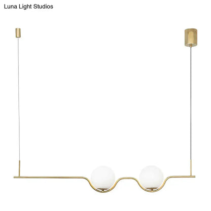 Minimalist gold metal island pendant ceiling light with two white glass spherical shades for dining table illumination