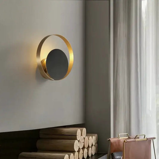 Minimalist gold nordic led wall sconce with a sleek circular gold-toned ring and dark central disc for bedroom lighting