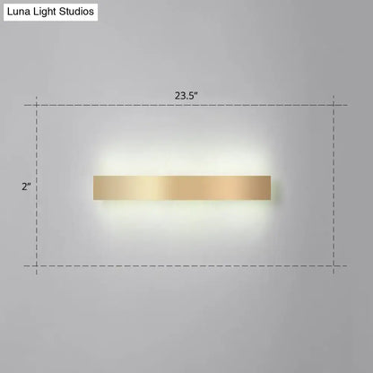 A sleek minimalist gold plated led wall sconce with a rectangular gold finish for living room or bar lighting