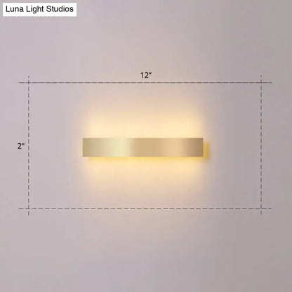 A sleek minimalist gold plated led wall sconce with a rectangular gold finish for living room or bar lighting