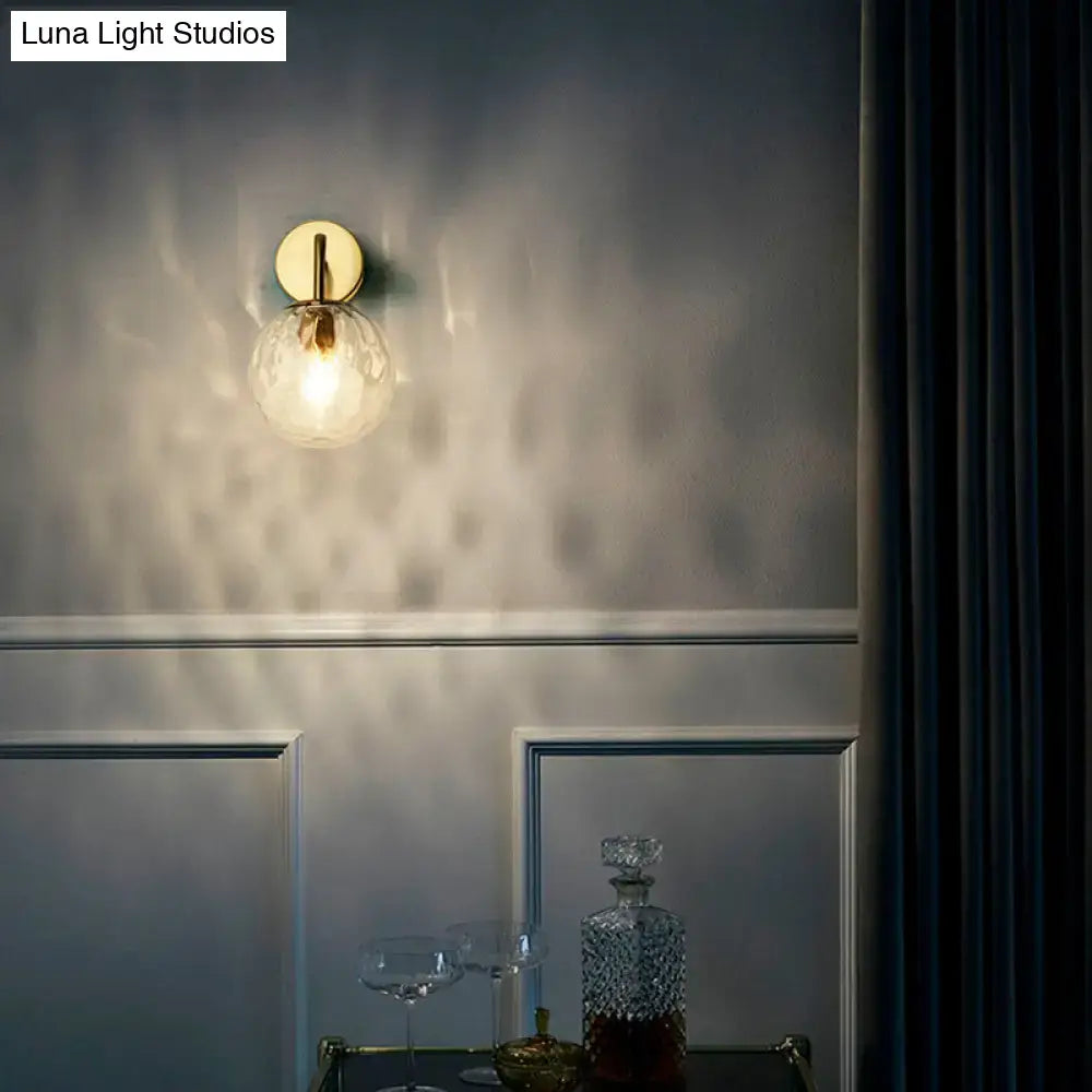 DecorBites™ minimalist wall lamp with warm brass gold sconce and clear rippled glass sphere 8 inches wide