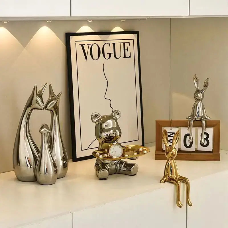 Shiny metallic bear figurine holding a small clock paired with decorbites gold rabbit ceramic ornaments for living room decor