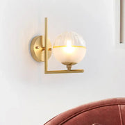 Minimalist gold wall lamp with textured glass globe and geometric frame features a stylish 12 inch fixture for bedrooms