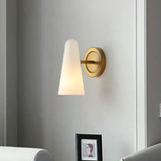 Minimalist gold wall sconce light with frosted glass shade and brushed brass base for living room lighting