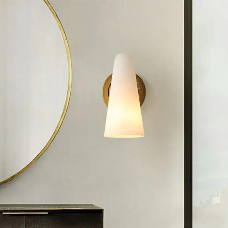 Minimalist gold wall sconce light with frosted glass shade and brass-finished backplate for living room use
