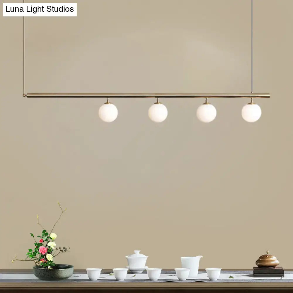 DecorBites™ modern minimalist pendant light with brass bar and frosted glass globes for dining room lighting