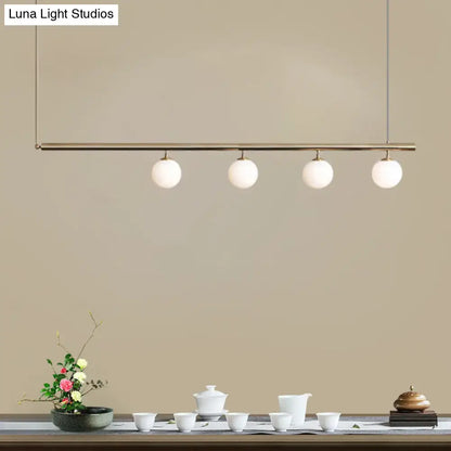 DecorBites™ modern minimalist pendant light with brass bar and frosted glass globes for dining room lighting