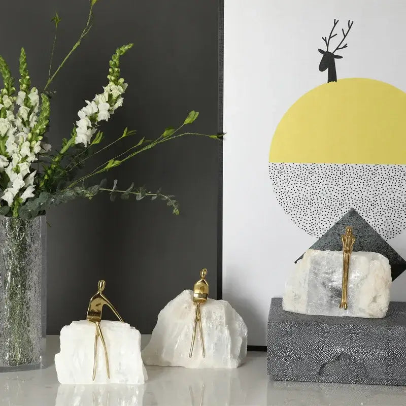 Minimalist golden man sculpture bookends with gold figurine sculptures on white rock bases for home decor by decorbites