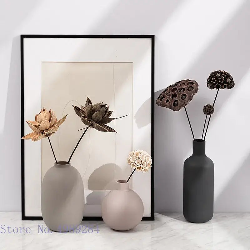 Three matte-finished colorful ceramic vases in gray pink and charcoal tones with dried lotus pods for decorbites colorful decor