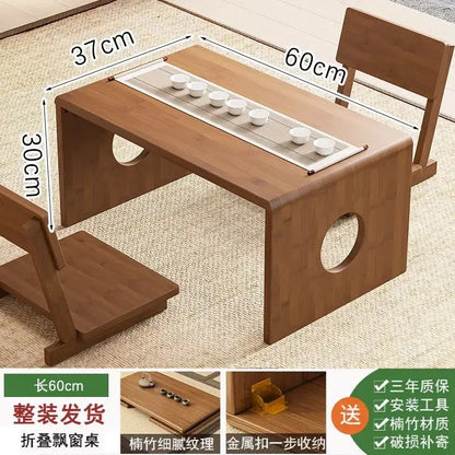 Minimalist light brown bamboo folding table with circular leg cutouts and built-in tray for six white ceramic teacups