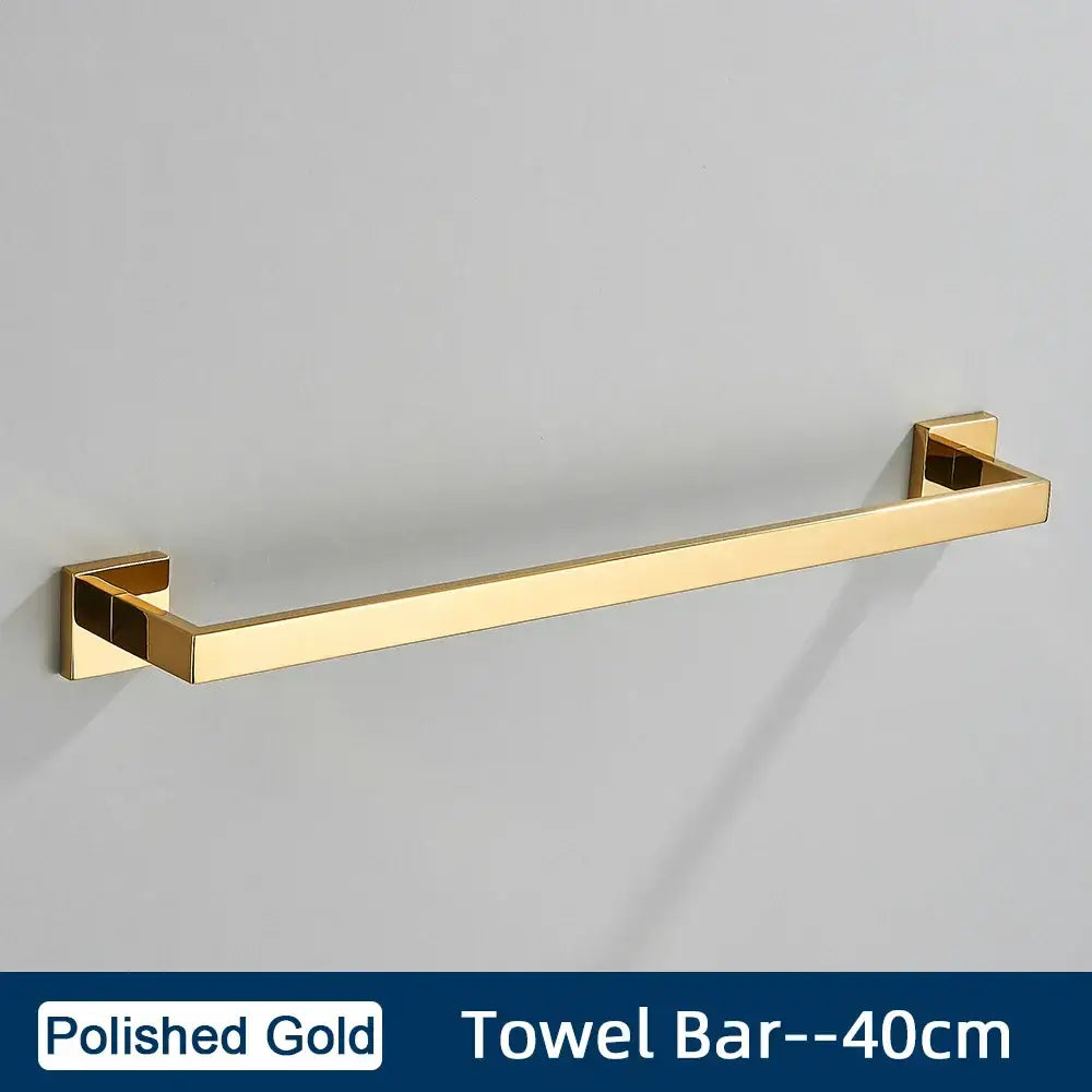 Polished gold towel bar with sleek rectangular design and square brackets in minimalist matte black stainless steel bathroom accessories set