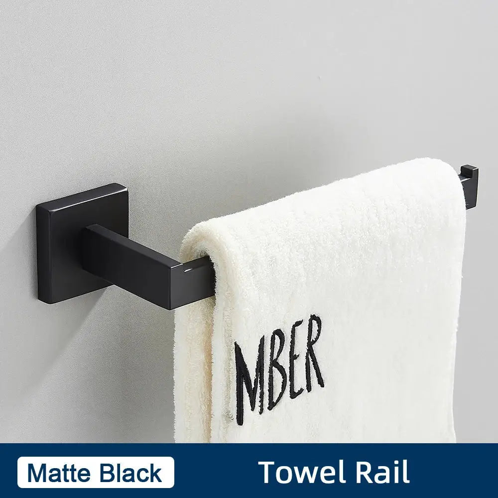Matte black stainless steel towel rail holding a white towel embroidered with mber in a bathroom accessories set