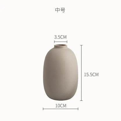 A matte beige minimalist decorbites geometric ceramic vase with rounded shape and narrow neck for living room decor