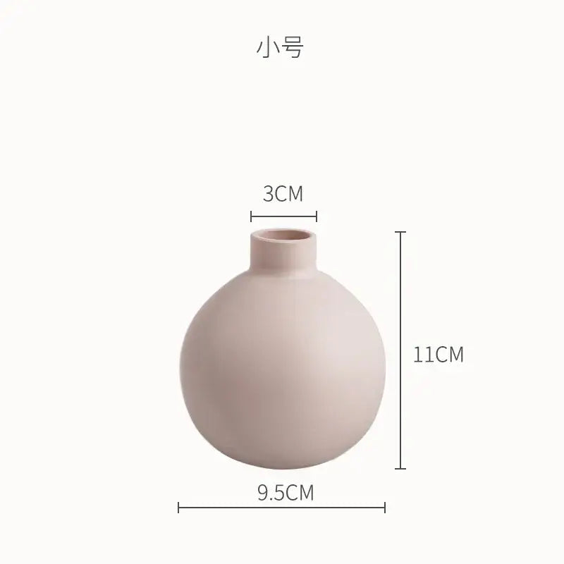 A small matte blush pink geometric ceramic vase with rounded body and narrow neck for minimalist decorbites decor