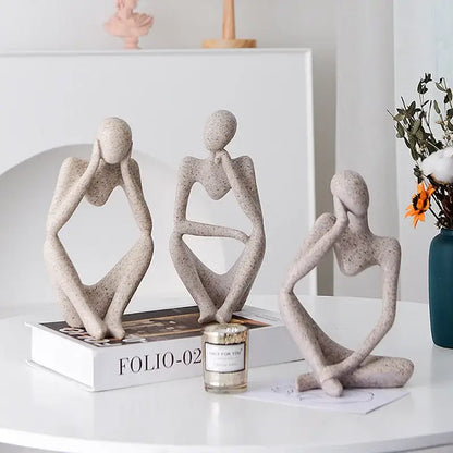Three abstract thinker woman figurines in speckled beige resin with contemplative poses for minimalist living room decor