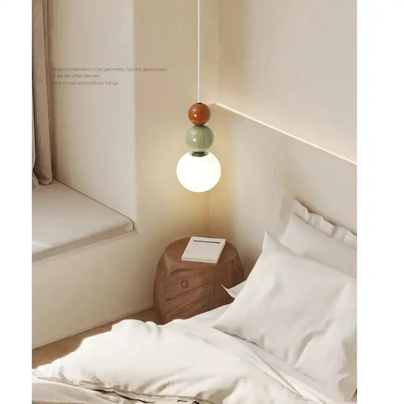 A minimalist nordic pendant light with three stacked terracotta sage green and white glass bulbs for bedroom decorbites cream style