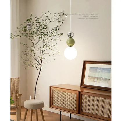 Minimalist nordic pendant light featuring a sleek silver sphere matte sage green orb and frosted white globe decorbites cream style