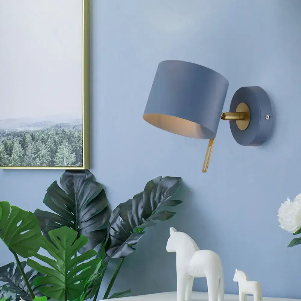 Modern gray wall sconce with brass accent and adjustable arm designed as minimalist pink and brass cylinder corridor light