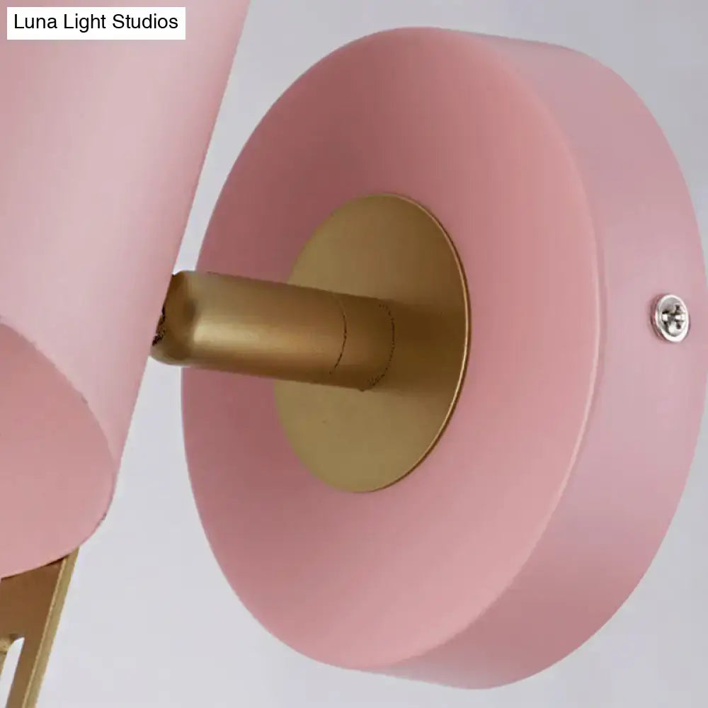 Minimalist pink and brass cylinder wall sconce with matte finish and gold-toned accents for corridor lighting