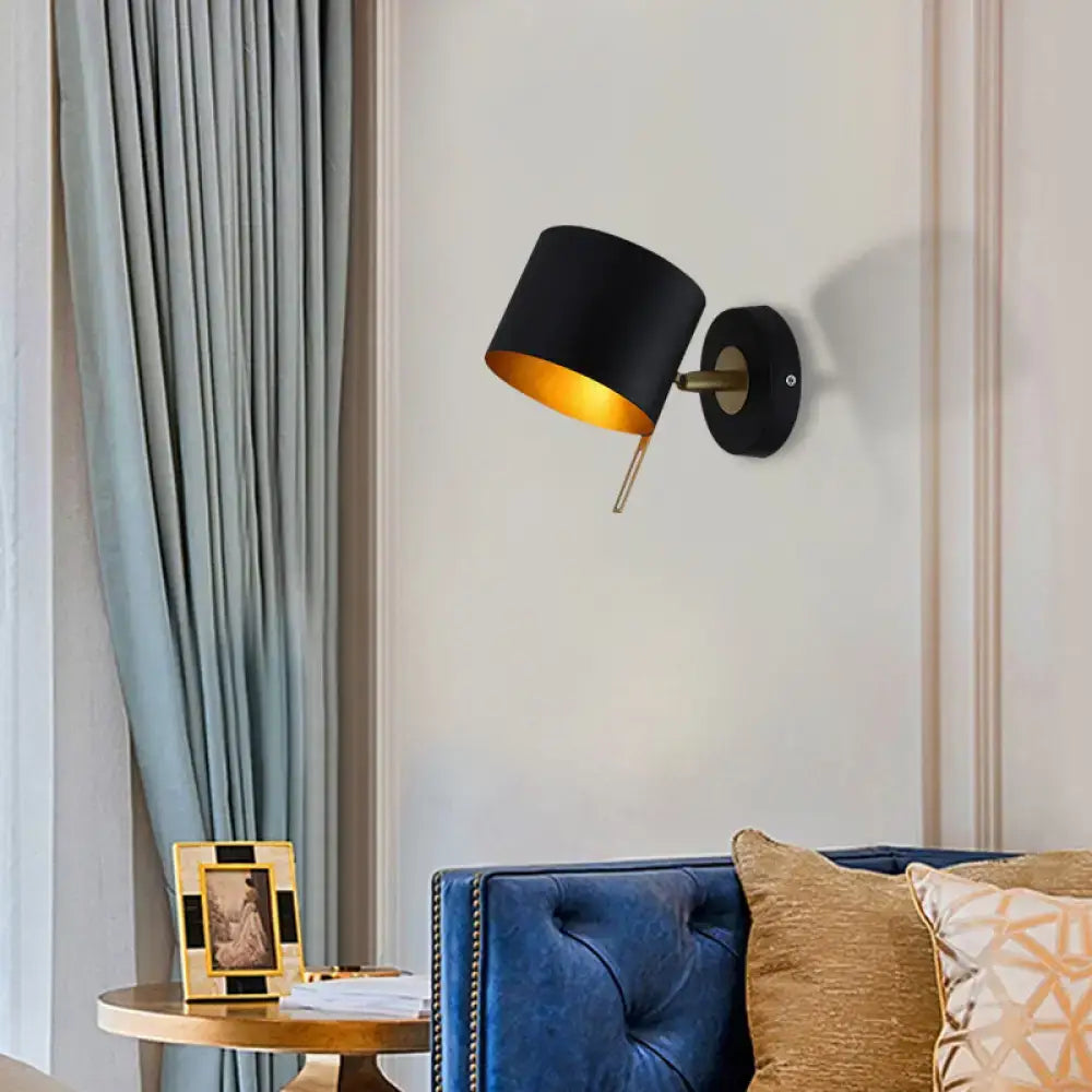 Black cylindrical wall sconce with gold interior and brass accents for minimalist pink yellow corridor lighting