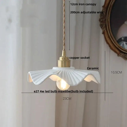 White ceramic pendant light fixture with fluted petal design and brass accents for minimalist kitchen lighting