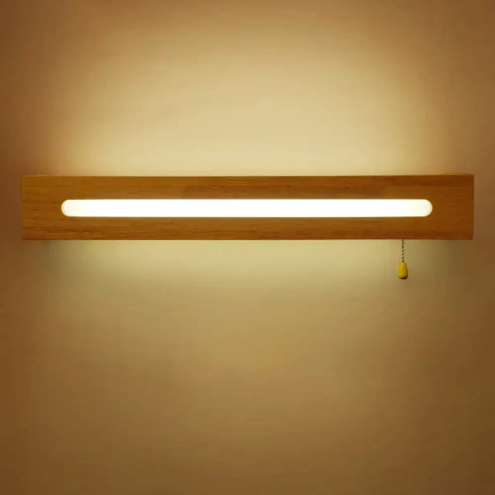 Minimalist rectangular wooden wall sconce with elongated led bulb included and yellow pull chain for bedroom lighting