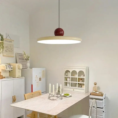 Minimalist red and white acrylic pendant light with a glossy red spherical top and cream shade for dining room cord pendant